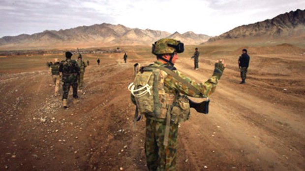 Australian and Afghan soldiers patrol for Taliban insurgents close to the scene of yesterday's deadly ambush.