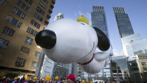 A giant Snoopy balloon is marched through Columbus Circle during the Annual Macy's Thanksgiving Day Parade.