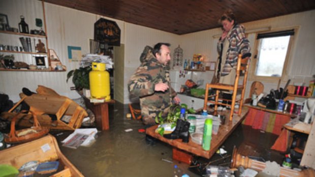 Two people wait in their drenched kitchen for rescuers after heavy floods in La Faute-sur-Mer, France.