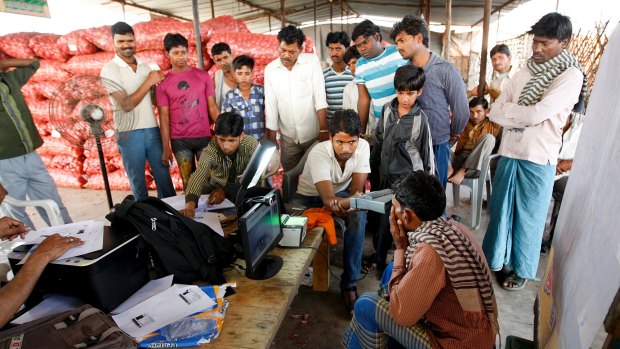 Homeless workers scan their irises and fingerprints for a national ID at a market in New Delhi in 2011.