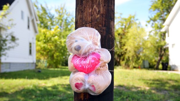 A teddy bear wrapped in plastic is tied to a utility pole in Cleveland, where paramedics tried to revive 5-month-old Aavielle Wakefield the night before. 