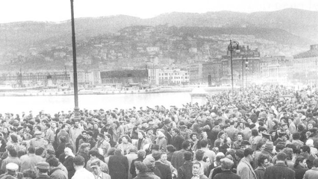 Crowds wait for a ship on the dockside at Trieste.
