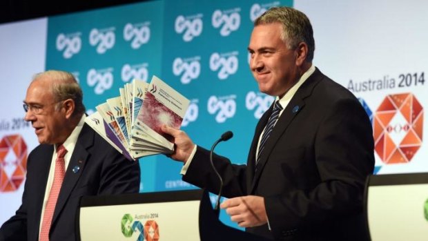 Joe Hockey holds up a report with OECD secretary-general Angel Gurria in Cairns.