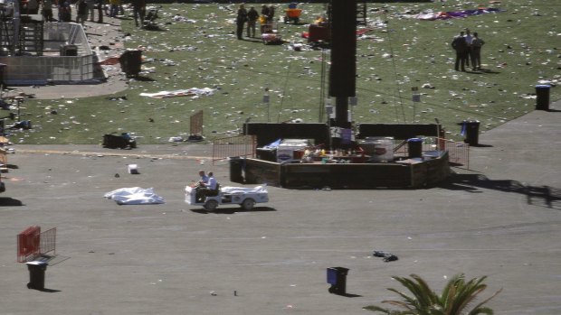 People drive a cart through the scene of a mass shooting at a music festival on the Las Vegas Strip.