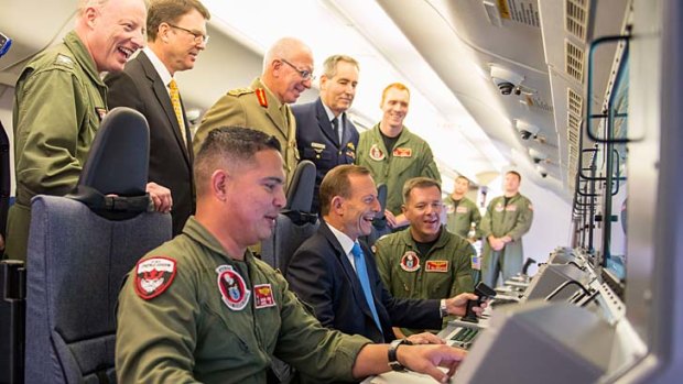 I spy: Prime Minister Tony Abbott inspects a Poseidon aircraft in Canberra on Friday. <i>Photo: US embassy</i>