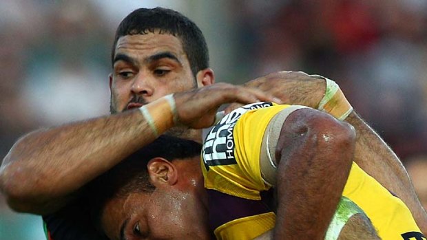 Greg Inglis of the Rabbitohs is tackled by Justin Hodges.