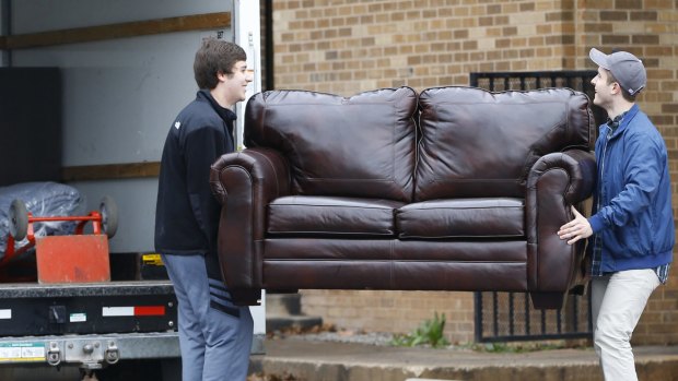Two men load a couch from the now closed University of Oklahoma's Sigma Alpha Epsilon fraternity house into a moving truck in Norman, Oklahoma.