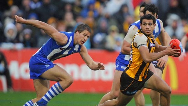 Catch me if you can: Hawk Cyril Rioli leads Andrew Swallow a merry dance.