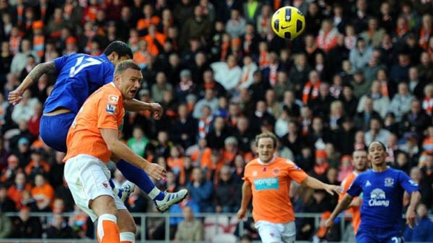 Tim Cahill jumps above Ian Evatt to score his side's first goal against Blackpool.
