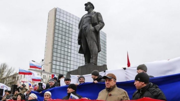 Pro-Russian demonstrators form a Russian flag as they stand under a statue of Soviet revolutionary leader Vladimir Lenin during a rally in Donetsk, Ukraine, on Sunday.
