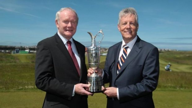 Northern Ireland Deputy First Minister Martin McGuinness and First Minister Peter Robinson hold the Claret Jug trophy at a media announcement that golf's oldest championship would return to Royal Portrush in Northern Ireland.