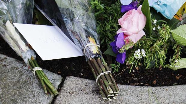 A hand drawn condolence is shown in front of Jobs' house in Palo Alto, California.