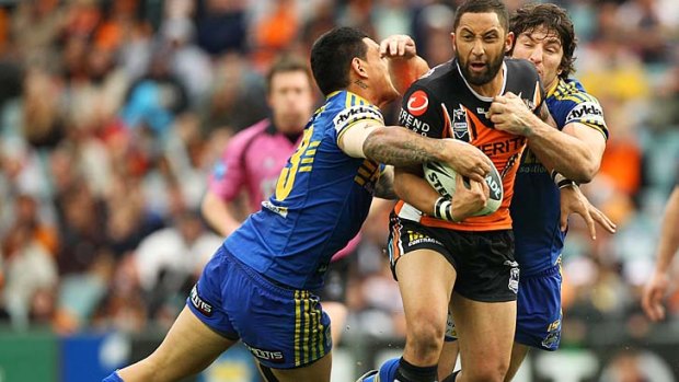 Benji Marshall of the Tigers is hauled in by the Parramatta defence.
