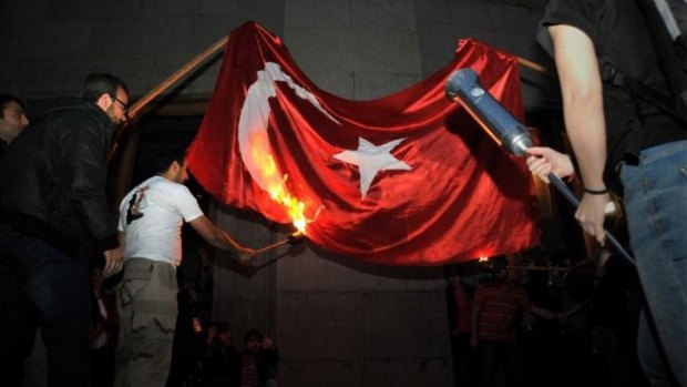 Hostility: men set fire to the Turkish flag to commemorate the 99th anniversary of the genocide in the Armenian capital Yerevan.