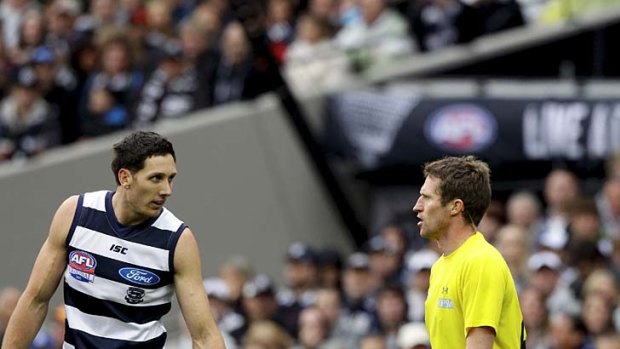 Not a goal... Geelong's Harry Taylor tells field umpire Shaun Ryan that a shot for goal by Sharrod Wellingham (not in pic) during the 2011 grand final hit the post.