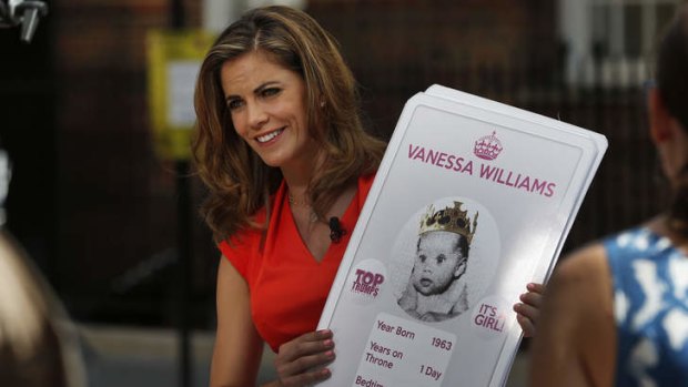 Broadcaster Natalie Morales of NBC holds placards made by a games company featuring a picture of guest co-host Vanessa Williams as a 'royal baby' during a live broadcast across St. Mary's Hospital exclusive Lindo Wing in London.