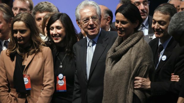 Italy's Prime Minister Mario Monti poses with supporters at the end of a meeting in Rome February 15, 2013.