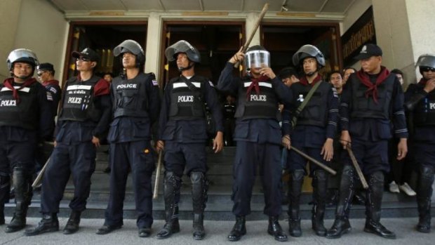 Police stand guard at a government building in Bangkok.