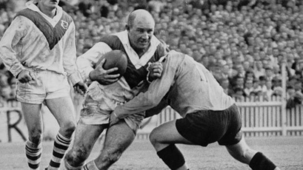 Simpler times: St George’s Brian Clay shrugs off a classic one-on-one tackle during the 1966 grand final.