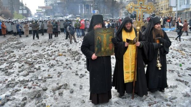 Orthodox priests pray during a lull in the fighting on Tuesday.