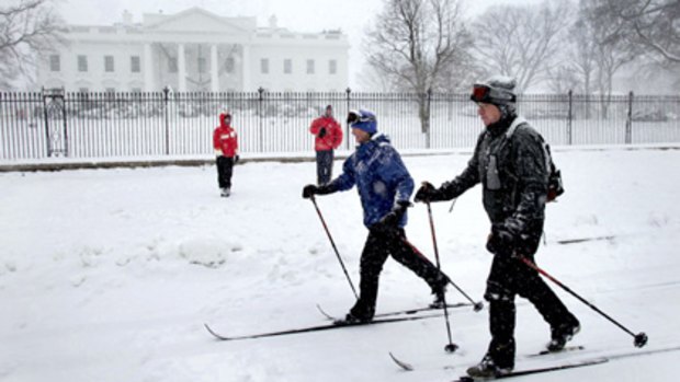 A couple ski past the White House on Saturday as a storm that broke all December records for snowfall crippled Washington, forcing authorities to declare a state of emergency. Warnings were in effect from North Carolina and Tennessee to New Jersey and Connecticut.