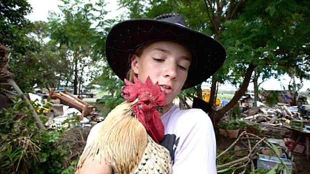 Katherine Godley cuddles her rooster, Steven, who survived the floods.