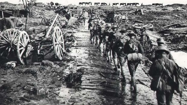 Australian troops in Flanders trudge along a timber road sinking into the mire.