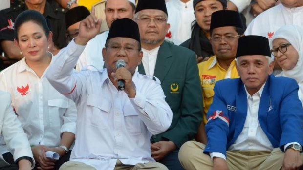 Defiant: presidential candidate Prabowo Subianto (with finger raised) is flanked by his ex-wife Hediati Suharto and running mate Hatta Rajasa at a rally earlier this week.