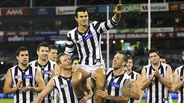 Riding high: Collingwood’s Chris Tarrant is carried from the field after his 250th game last night.