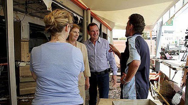 Queensland Governor Penelope Wensley and Ipswich Mayor Paul Pisasale manage to share a joke with the owners of Big Dad's Pies amongst the devastation caused by the floods.