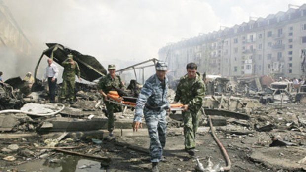 Policemen and soldiers work at the site of an explosion in a police station in Nazran, southern Russia.