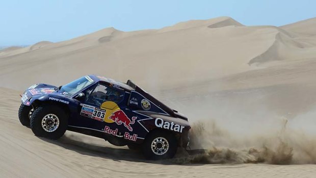 Carlos Sainz and co-pilot Timo Gottschalk of team Buggy compete in the special stage on day one of the 2013 Dakar Rally in Pisco, Peru.