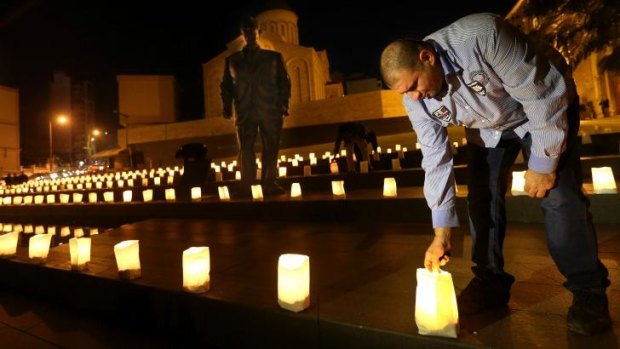 A supporter of slain former Lebanese prime minister Rafiq al-Hariri lights candle during a vigil in front of Hariri's statue in Beirut.