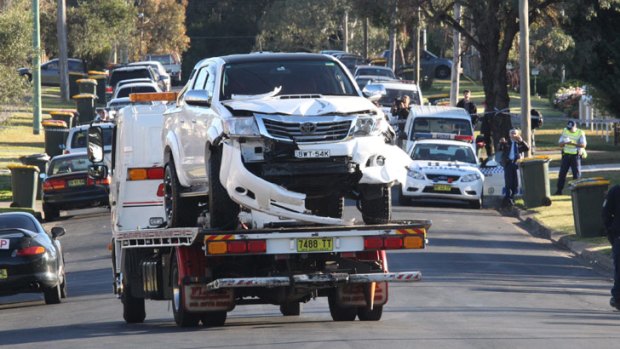 A tow truck removes the crashed ute from the scene of a double shooting in Sydney's west.