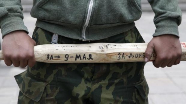 A man holds a stick outside the regional government headquarters in Luhansk, eastern Ukraine.