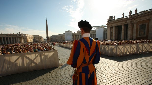 A Swiss Guard on patrol at the start of the General Audience with the Pope, attended by thousands of people in St Peter's Square at the Vatican.