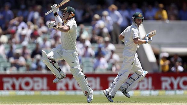 David Warner runs past captain Michael Clarke as he celebrates scoring a century at the Adelaide Oval.