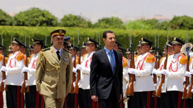 Syrian President Bashar al-Assad (centre) reviews an honour guard ahead of being sworn in.
