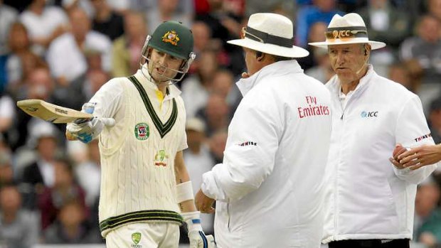 Michael Clarke with umpires Tony Hill (R) and Marais Erasmus after play is stopped for bad light.