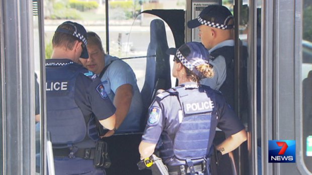 Police speak to a bus driver after he was punched by a passenger.