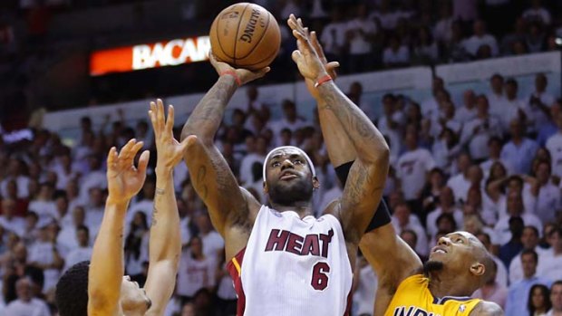 Miami Heat's LeBron James (C) scores against Indiana Pacers' Gerald Green (L) and Paul George.