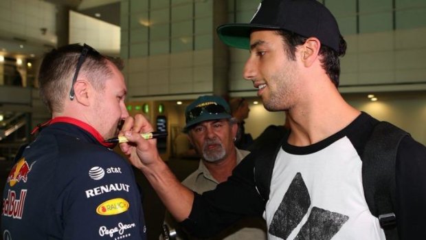 Daniel Ricciardo signs a fan's shirt after returning to Perth this week.