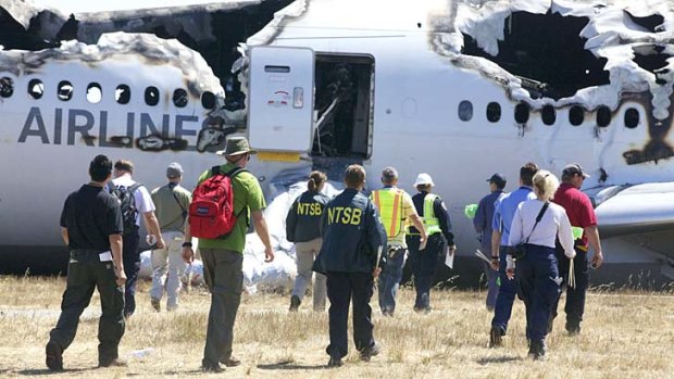 Investigators examine the wreckage at the scene of the Asiana flight which crashed upon landing Saturday, July 6, at San Francisco International Airport.
