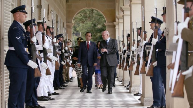 Widodo, center left, walks through an honor guard escorted by Australian Governor-General Sir Peter Cosgrove, center right, as they arrive at Admiralty House in Sydney.