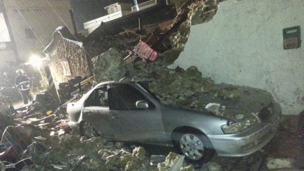 Seen in a raining downpour, a vehicle is covered in rubble from the wreckage from a TransAsia plane that crashed while attempting to land in typhoon weather on the Taiwan island of Penghu, 150 kilometers off Taiwan.