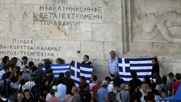 Anti-EU protesters hold Greek flags in front of Parliament  during a demonstration of about 500 people in Athens.