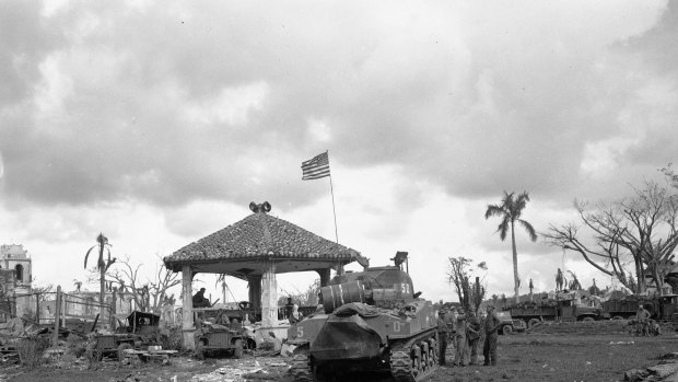 Guam during World War Two. This August 1944 file photo shows an American flag atop the first US tank to lead the push to Agana, capital of Guam. 