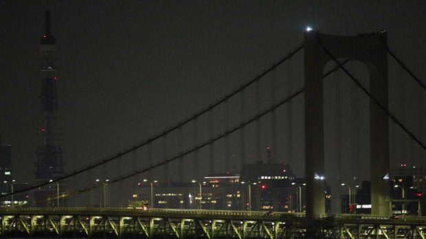 Most lights were switched off on the Tokyo Rainbow Bridge last night  and on the Tokyo tower in the background.