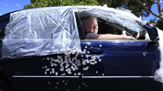 Graham Wilson sits in his car which was involved in a drive by shooting in Canberra.