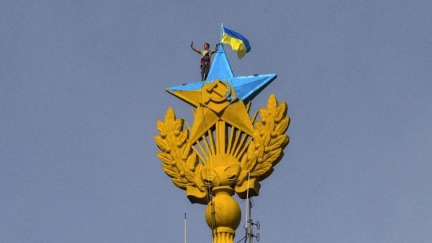 A worker takes a selfie before removing the Ukrainian flag.